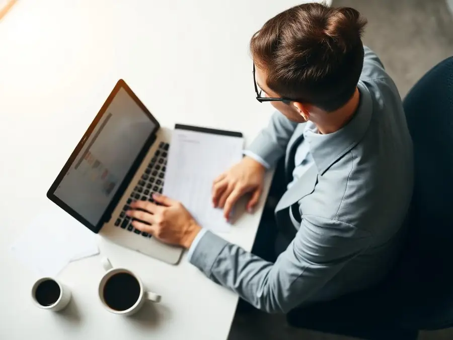 Hiring manager reviewing candidate applications on a laptop
